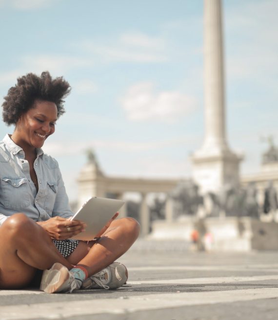 woman sitting in the street uses a tablet
